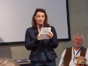 Nicola Bryant (with Terry Molloy in background) talking at a panel. (Photo by Pascal Salzmann)